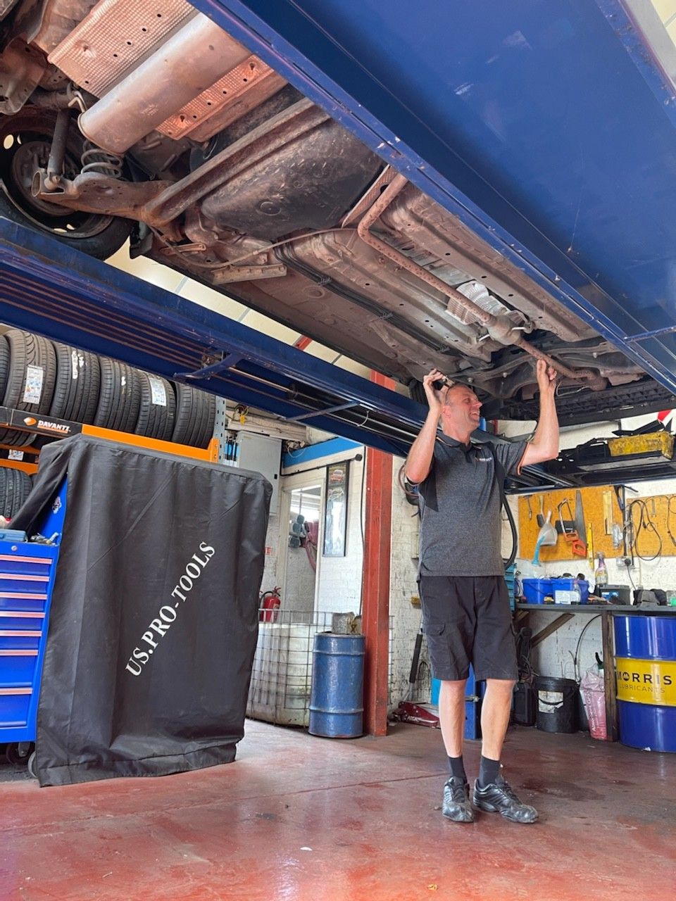 Mechanic picking up a tyre - Tyres Worcester